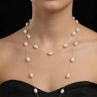 Pearl necklace on a black mannequin against a black background