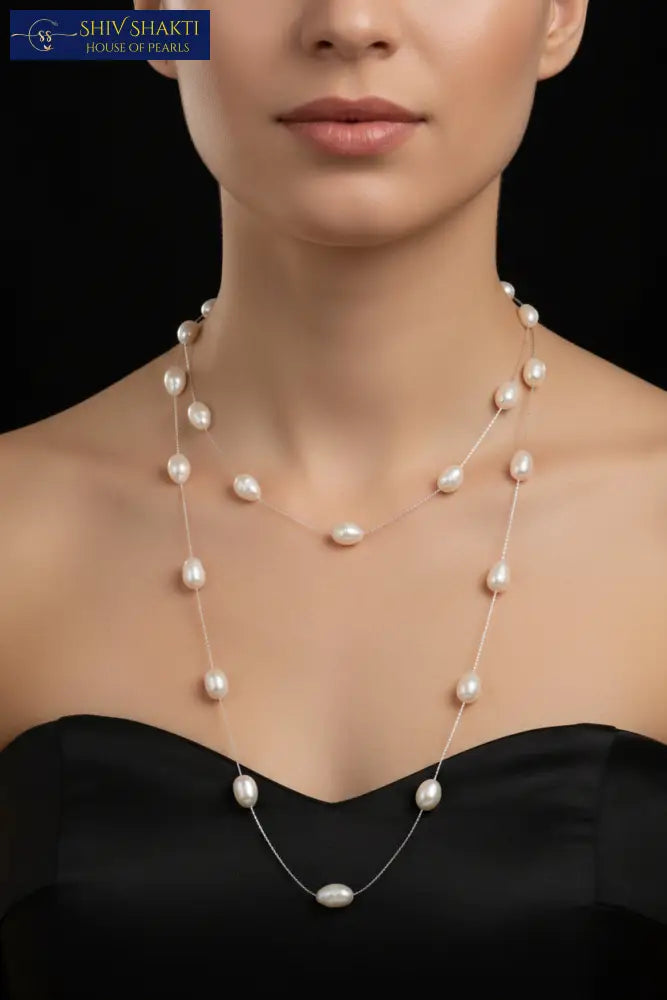 Pearl necklace on a black mannequin against a black background