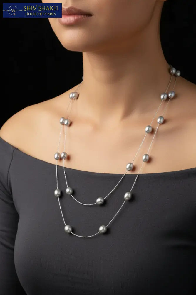 Pearl necklace on a black mannequin against a black background
