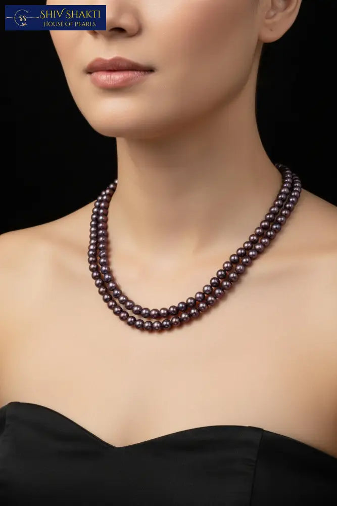Pearl necklace on a black mannequin with a dark background