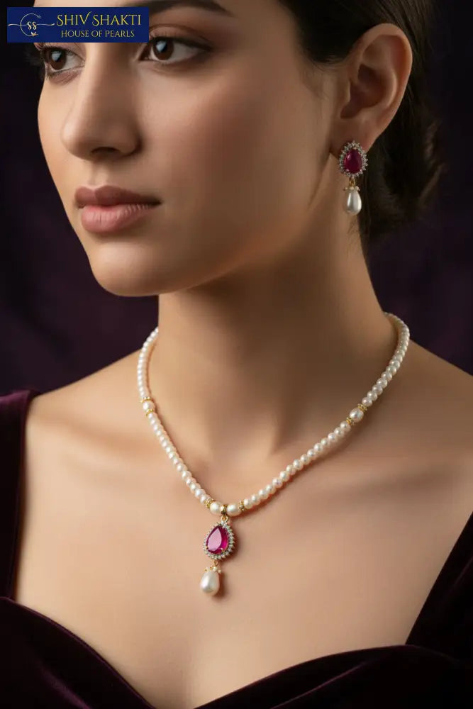 Pearl necklace with red gemstones on a black mannequin against a dark background