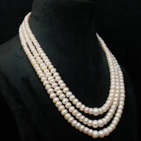 Three-strand pearl necklace on a black mannequin