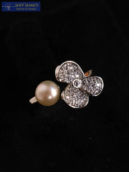 Jewelry with a pearl and diamond-studded flower design on a black background