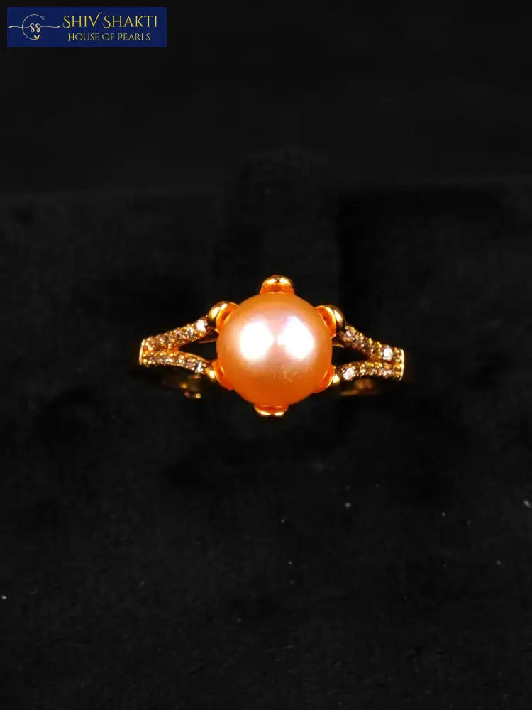 Gold ring with a large orange gemstone on a black background