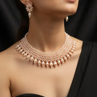 Pearl necklace and earrings set on a black background