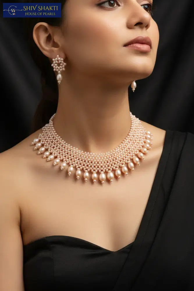 Pearl necklace and earrings set on a black background